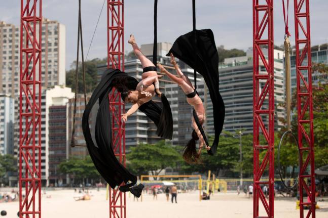 Members of the aerial circus group Pendurados perform in an open-air show that explores healing from sexual violence through art and community, at Icarai Beach in Niteroi, Rio de Janeiro.