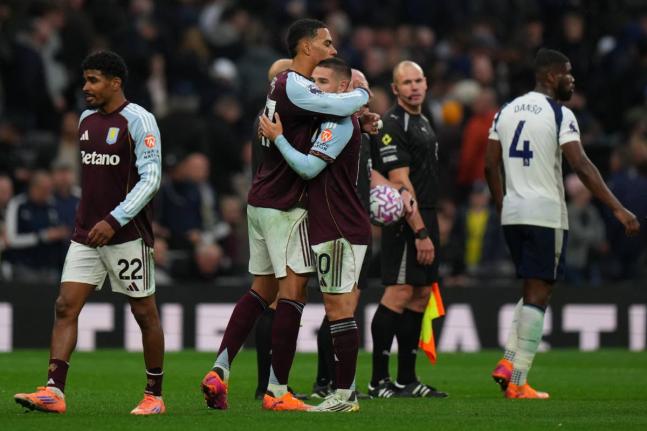 Aston Villa's Emiliano Buendia, right and teammate Aston Villa's Donyell Malen embrace at the end of the English Premier League soccer match between Tottenham Hotspur and Aston Villa in London, Sunday, October 19, 2025. (AP Photo/Joanna Chan)