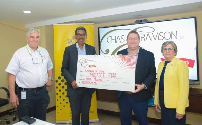 Phillip Ramson (second right), managing director of Chas E. Ramson Limited, presents a symbolic cheque valued at $4 million to Project STAR Director, Ian Neita (second left), marking the company’s two-year partnership with Project STAR to support communi