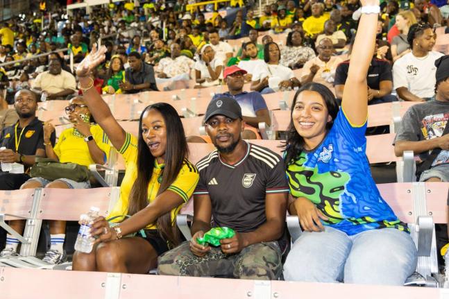 Brittany Thwaites (right), brand manager, WATA portfolio, Wisynco Group, shares a moment with football fans Lavonia (left) and Gerzan Williams (centre) in the stands at the National Stadium on Tuesday, October 14. The interaction formed part of WATA’s Ce
