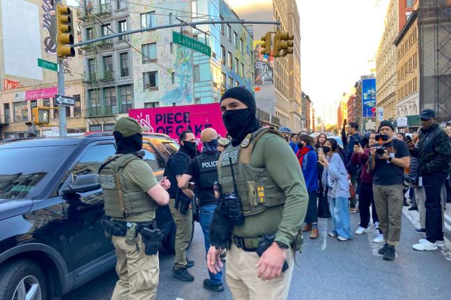 Federal agents conduct an immigration sweep on Canal Street in Chinatown as protesters gather, Tuesday, October 21, 2025, in New York. (AP Photo/Jake Offenhartz)