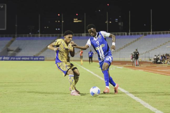 Mount Pleasant winger Daniel Green takes on Defence Force FC’s Christian Bailey during their Concacaf Caribbean Cup first-leg semi-final football game inside the Hasely Crawford Stadium on Wednesday, October 22, 2025.