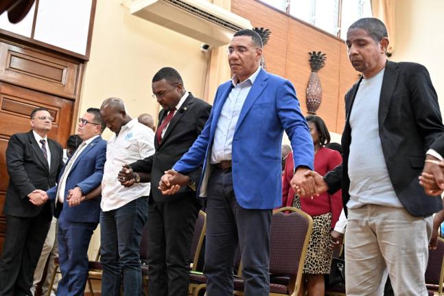 Prime Minister Dr Andrew Holness (second right) prays with his ministers (from left) Matthew Samuda, minister of water, environment and climate change; Pearnel Charles Jr, minister of labour and social security; Robert Morgan, minister without portfolio in