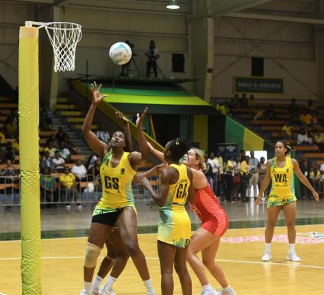 Sunshine Girl Romelda Aiken-George (left) gets into position to grab a rebound during a netball match in the Horizon Netball Series against the England Roses at the National Indoor Sports Centre on November 26, 2024. Looking on at second right is Shanice B