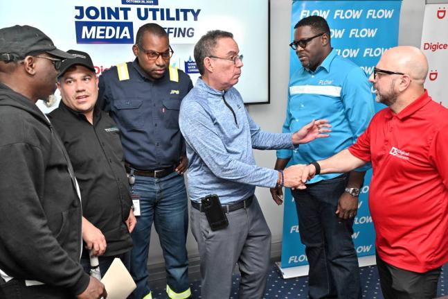Matthew Samuda (second left), minister of water, environment and climate change; and Daryl Vaz (third right), minister of science, energy, telecommunications and transport; speak with from left Stephen Shaw, communications specialist, at the NWA; Hugh Gran