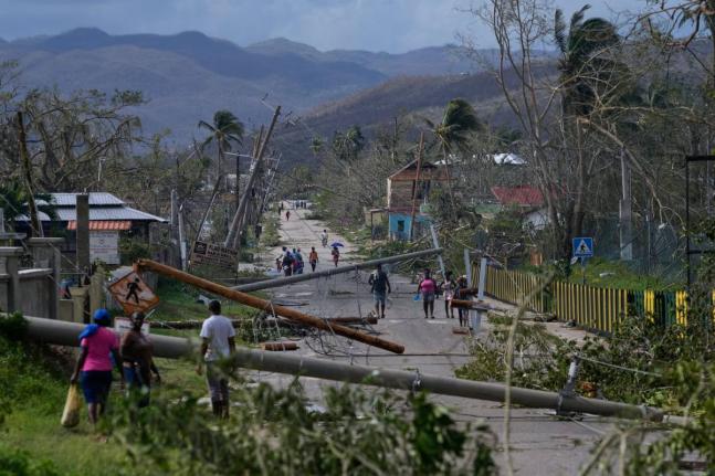 Residents walk through Lacovia Tombstone, Jamaica, in the aftermath of Hurricane Melissa.