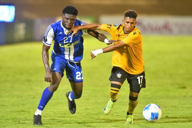 Ranaldo Biggs (left) of Mount Pleasant and Universidad O&M’s Reyvin de la Rosa battle for the ball during their Concacaf Caribbean Cup match at the National Stadium on September 30. Mount Pleasant won 2-0. 