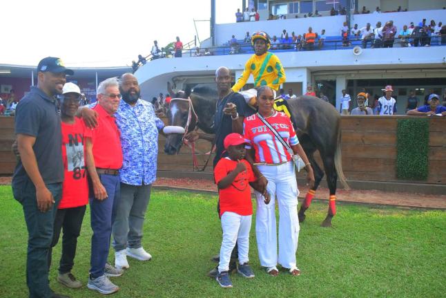 
Supreme Ventures Racing and Entertainment Limited’s chairman Solomon Sharpe (fourth left) hugs trainer Philip Feanny after his charge RIDEALLDAY, with jockey Paul Francis in the saddle, parades in the winners enclosure with winning connections following