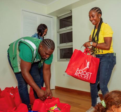 Shelly-Ann Fraser-Pryce (right), founder of the Pocket Rocket Foundation, joins volunteers last Friday in assembling care packages for families impacted by Hurricane Melissa. The initiative forms part of the Foundation’s national relief drive to support 