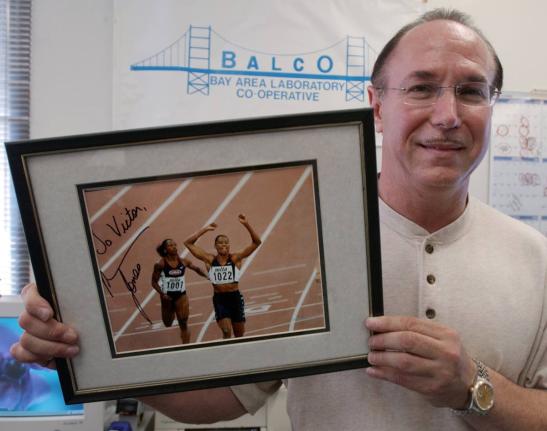 BALCO founder Victor Conte holds up an autographed photo of track star Marion Jones addressed to him in his office in Burlingame, California, on October 21, 2003. 