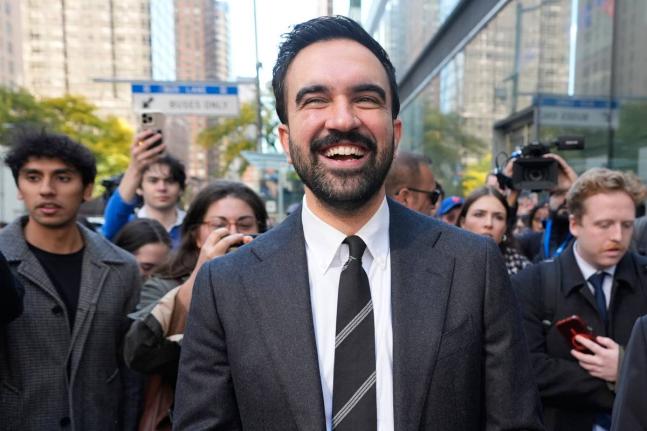 Zohran Mamdani tries to talk to pedestrians while surrounded by reporters in New York, Monday, October 27, 2025. (AP Photo/Seth Wenig)