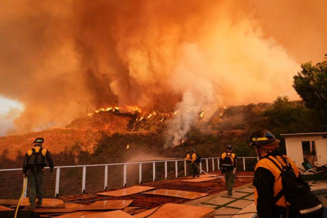 Fire crews monitor the Palisades Fire in Mandeville Canyon on January 11, 2025, in Los Angeles.