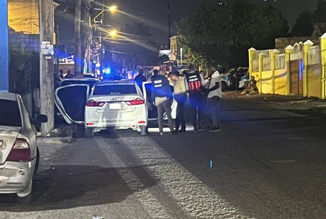 Police personnel at the crime scene along Waltham Park Avenue in St Andrew, in the vicinity of 83 Lane, where two off-duty cops were shot dead last night.
