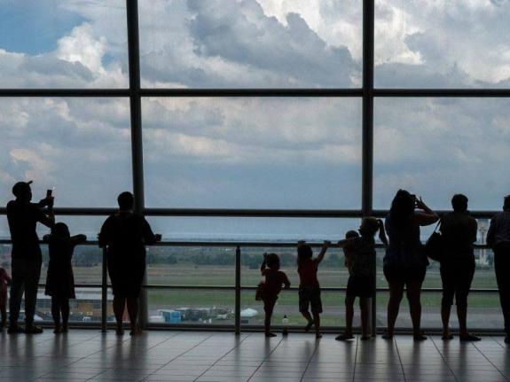 Families watch planes on the tarmac at Johannesburg's OR Tambo's airport, Monday November 29, 2021. (AP Photo/Jerome Delay, File)