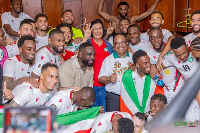 President of Suriname Jenny Simons and Vice-President Gregory Rusland (centre) celebrate with the Natio players in the locker room after their victory over El Salvador on Thursday.