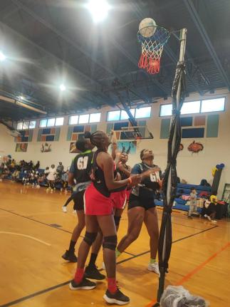 Jamaica's Police National Netball team's goal attack, Marcella Thompson (nearest), watches as goal shoot Kenesha Beckett (partially hidden) scores against Tampa Bay during their second game at the Florida United Netball Extravaganza at the Miramar Youth En