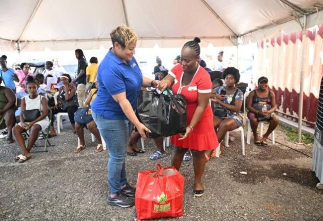 State Minister in the Ministry of Health and Wellness, Krystal Lee (left), hands over a care package to expecting mother Shanae Cooper-Robinson during a maternal health outreach at the Black River Health Centre in St Elizabeth on November 21.