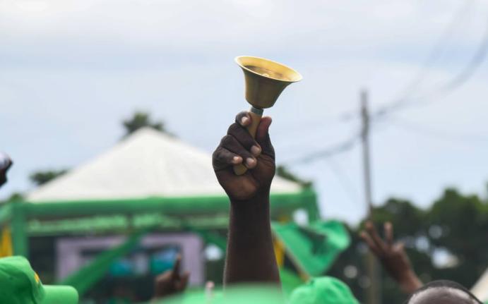 A Jamaica Labour Party supporter rings a bell at the party's 81st Annual Conference at the National Arena in Kingston on November 24, 2024.