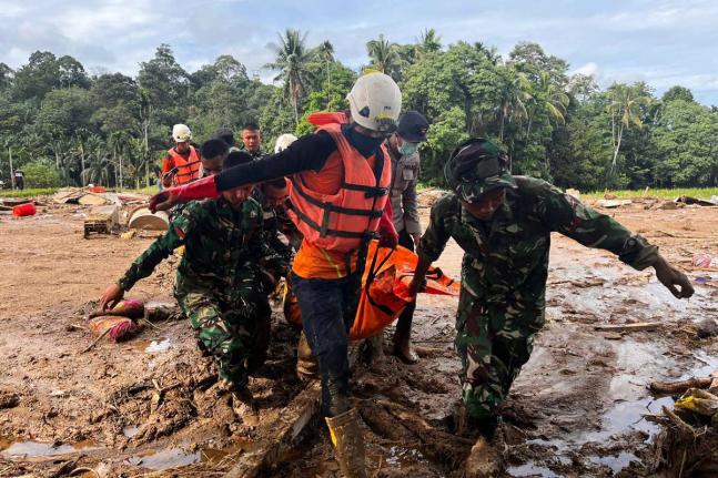 Rescuers carry the body of a flood victim in Agam, West Sumatra, Indonesia.