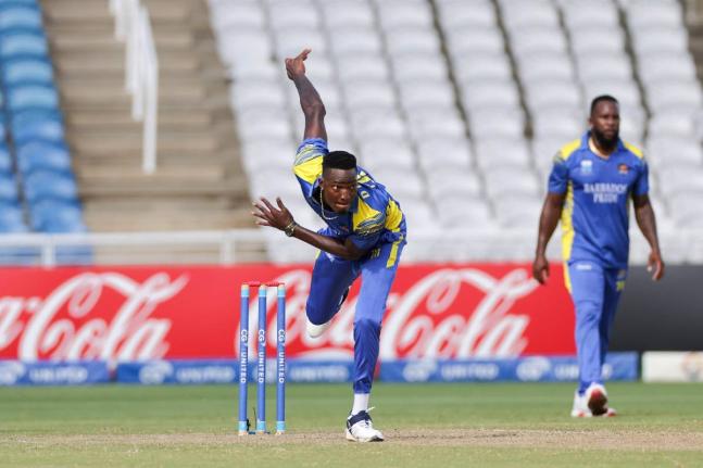 Barbados Pride bowler Dominic Drakes bowls under the watchful eyes of his captain Kyle Mayers during the final of the CGI Super50 against the Trinidad and Tobago Red Force at the Brian Lara Cricket Academy in Couva on Saturday.