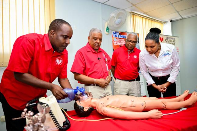 Heart Foundation of Jamaica (HFJ) Training Manager, Alonzo Mothersill (left), demonstrates an emergency procedure on a child mega code, during the November 26 handover of equipment donated by CHASE Fund at the HFJ’s Beechwood Avenue location. Observing (