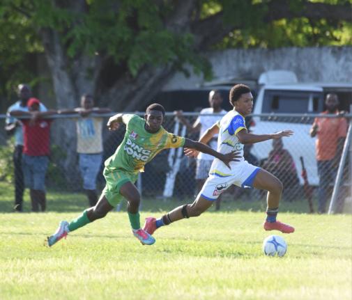 St. Elizabeth Technical High School’s (STETHS) R-Jay Newman (right) dribbles by Ocho Rios High’s Demar Tyson during their round of 16 of the ISSA daCosta Cup match at Drax Hall Sports Complex yesterday. STETHS won 3-0.