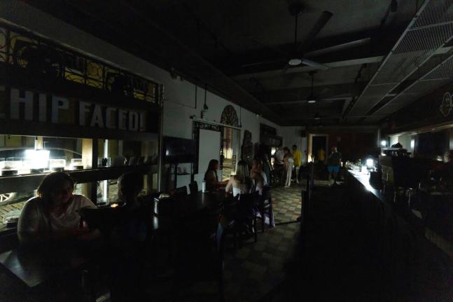 Customers sit inside a restaurant lit by battery-powered lanterns during an islandwide power outage, in Old San Juan, Puerto Rico, April 16, 2025. (AP Photo/Alejandro Granadillo, File)