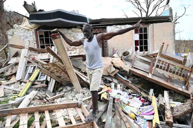 Glenroy Brown stands on the rubble left of a section of his home in Beeston Spring after Hurricane Melissa.