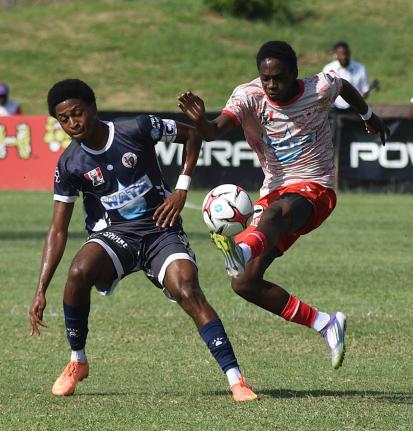 Mona High School’s Savi-k Morton (right) controls a ball ahead of Jamaica College’s Dontae Logan during their ISSA/WATA Manning Cup round-of-16 football match at the Stadium East field yesterday. The game ended 2-2.