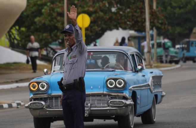 A National Police officer directs traffic due to a power outage in Havana, Cuba, Wednesday, December 3, 2025.