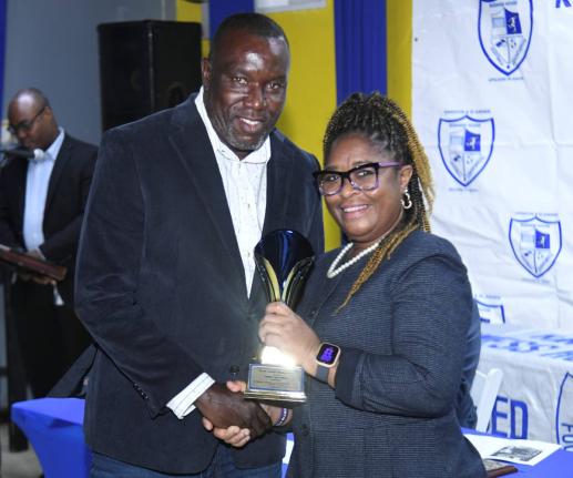 Mount Pleasant Football Academy head coach, former national player Theodore Whitmore (left), receives the Abe Alexander Award for Excellence from assistant general secretary Karen Bogle at the Kingston and St Andrew Business House Football Association’s 