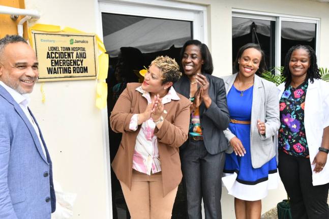 Minister of State in the Ministry of Health and Wellness, Krystal Lee (second left), applauds as she views the plaque dedicating the newly renovated Accident and Emergency Waiting Area at the Lionel Town Hospital in Clarendon, during the official opening o
