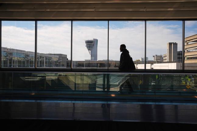 
A traveller moves in view of a control tower at Philadelphia International Airport in Philadelphia, Wednesday, November 5, 2025.