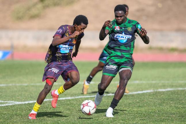 Kevaun Campbell (right) of Calabar High tries to keep up with a fast Shankeno Grant (left) of St Andrew Technical during a Manning Cup quarterfinal match at the Stadium East field on December 9.