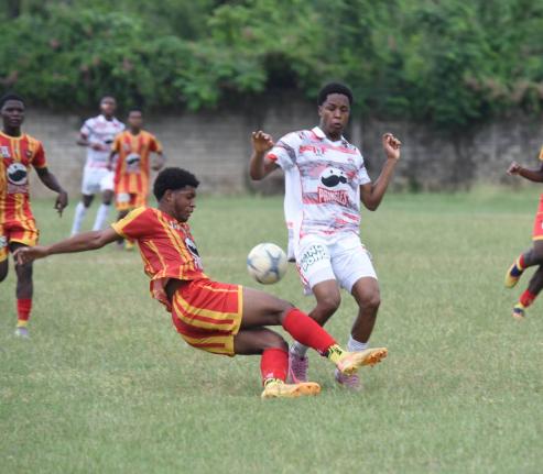 Ashley Anguin/photographer 
Glenmuir High School’s Dunsting Cohen (right) tries to evade the tackle of Cornwall College’s Khalid Fraser during their ISSA daCosta Cup quarter-final football match at Cornwall’s playing field yesterday. The game ended 1