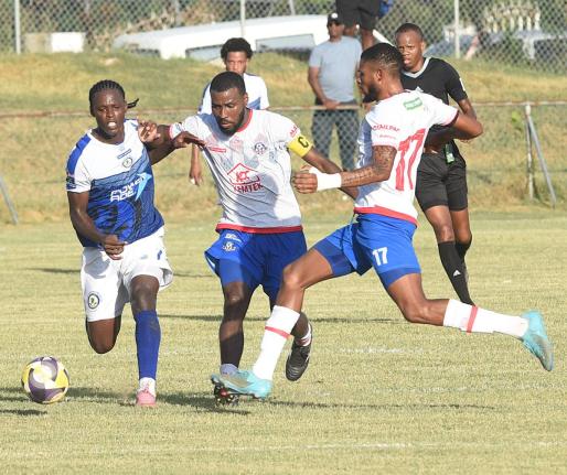 Gawain Austin (right) and Tarick Ximines (centre) of Portmore United challenge Mount Pleasant’s Warner Brown (left)  during their Jamaica Premier League match at Ferdi Neita Park yesterday.