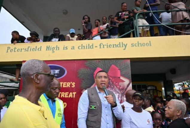 Prime Minister Dr Andrew Holness (centre) addressing residents at the Petersfield High School in Westmoreland on Saturday, December 13, 2025 during the Prime Minister’s Christmas Treat. Also participating were (from left) Minister of Local Government and