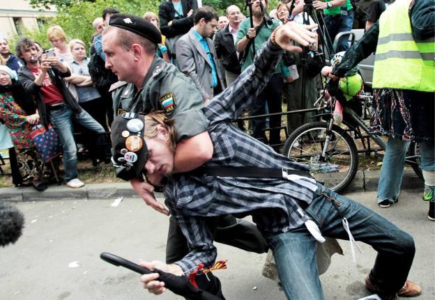 A police officer detains a supporter of the Russian punk group Pussy Riot outside a court in Moscow, Russia, Friday, August 17, 2012. A Moscow judge has sentenced each of the three members of the provocative punk band Pussy Riot to two years in prison on h