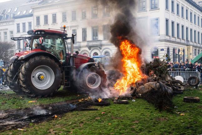Protestors burn tires during a demonstration of European farmers outside an EU summit meeting in Brussels on December 18, 2025. 