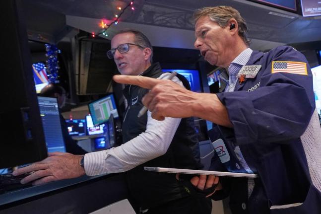 AP 
Specialist Glenn Carell, left, and trader Robert Charmak work on the floor of the New York Stock Exchange. 