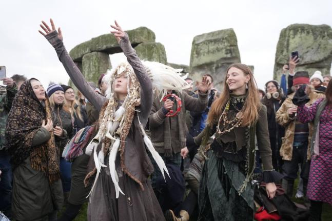 People take part in the winter solstice celebrations during sunrise at the Stonehenge prehistoric monument on Salisbury Plain in Wiltshire, England.
