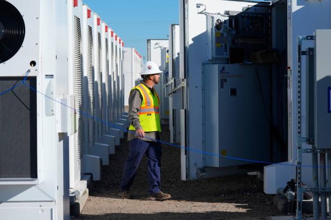 A worker does checks on battery storage pods at Orsted’s Eleven Mile Solar Center lithium-ion battery storage energy facility Feb. 29, 2024, in Coolidge, Ariz. AP