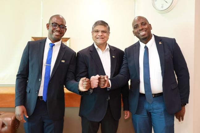 Robert Almeida, CEO of NCB Financial Group Limited (centre), shares a moment with Maurice Dawson (left), customer care agent, and Cordell Brown, business banker at NCB Fairview Financial Centre, before surprising them with a Grant a Wish donation to help c