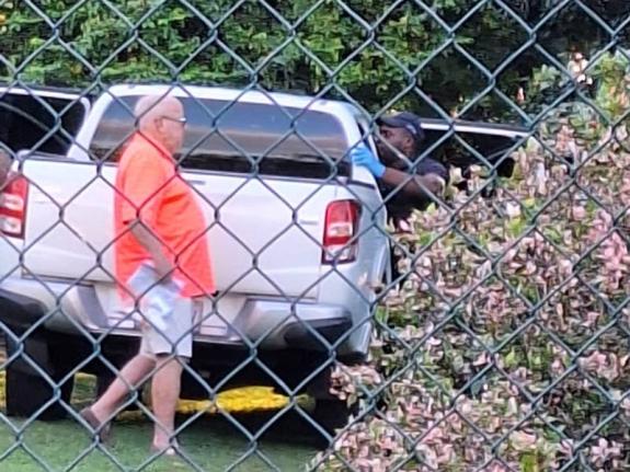 Hugh Croskery, founder of collapsed investment firm SSL, is seen behind a pickup truck being searched by police at a St Andrew residence on Wickham Avenue during a coordinated law-enforcement operation on December 27, 2025. 