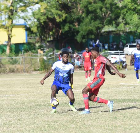 Mount Pleasant Academy’s Raheem Edwards (left) is challenged by Montego Bay United’s Philando Wing) during their Jamaica Premier League game at Jarrett Park yesterday. 