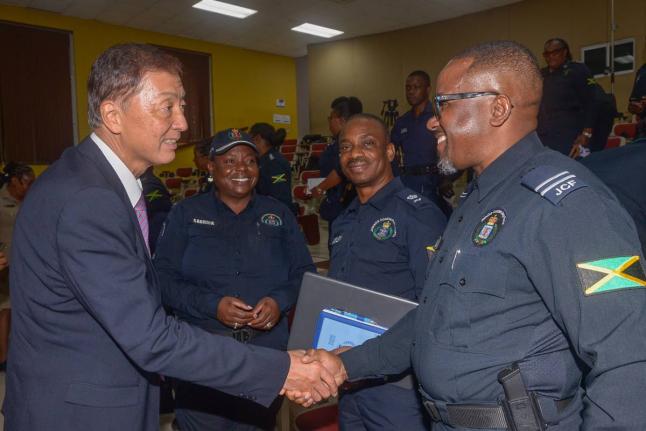 Ambassador of Japan to Jamaica, Yasuhiro Atsumi (left), greets Zonal Commander for the St Catherine North Police Division, Inspector Ismail Williams (right), at the closing-out ceremony for the Brazil-KOBAN community policing training programme, held at t