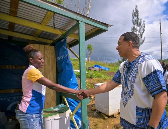 Prime Minister, Dr Andrew Holness, greets resident of Accompong, St Elizabeth, Coleen Hutchinson, during a tour of homes in the area on Tuesday, January 6, 2026. Hutchinson is among residents who have benefited from roof repair works being conducted in the