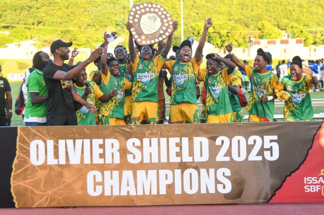 
Members of the Excelsior High School football team celebrate with the Olivier Shield after their 2-0 win over St Elizabeth Technical High School at the Stadium East field yesterday. 
