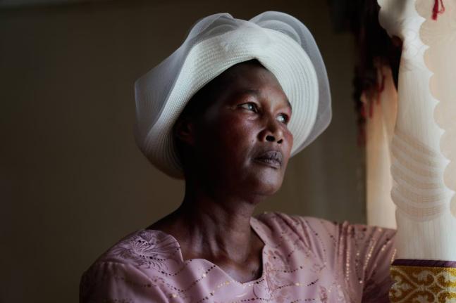 Anne Bonareri, a widow, looks out the window of her home in Kisii, Kenya on November 26, 2025. 