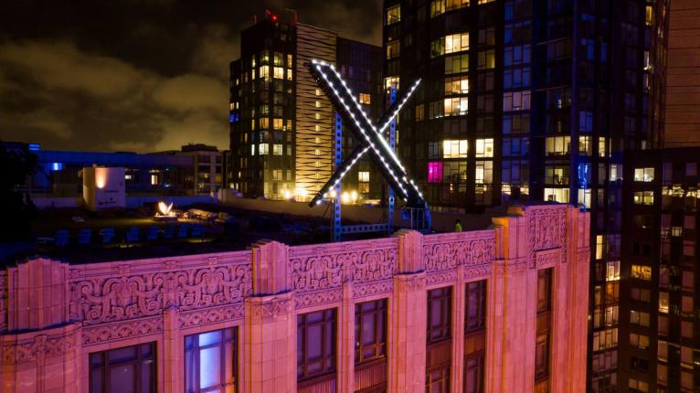 Workers install lighting on an ‘X’ sign atop the company headquarters, formerly known as Twitter, in downtown San Francisco, July 28, 2023.